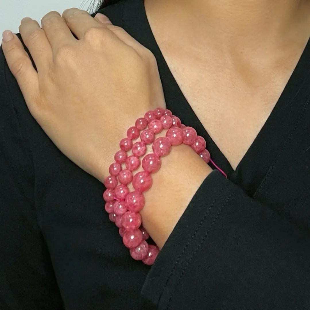 Bracelet en perles de rhodonite rose tendre porté au poignet