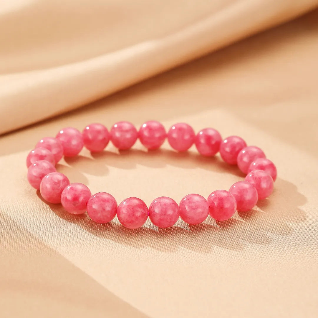 Bracelet Rhodonite "Rose Tendre" en perles roses, sur un fond beige satiné