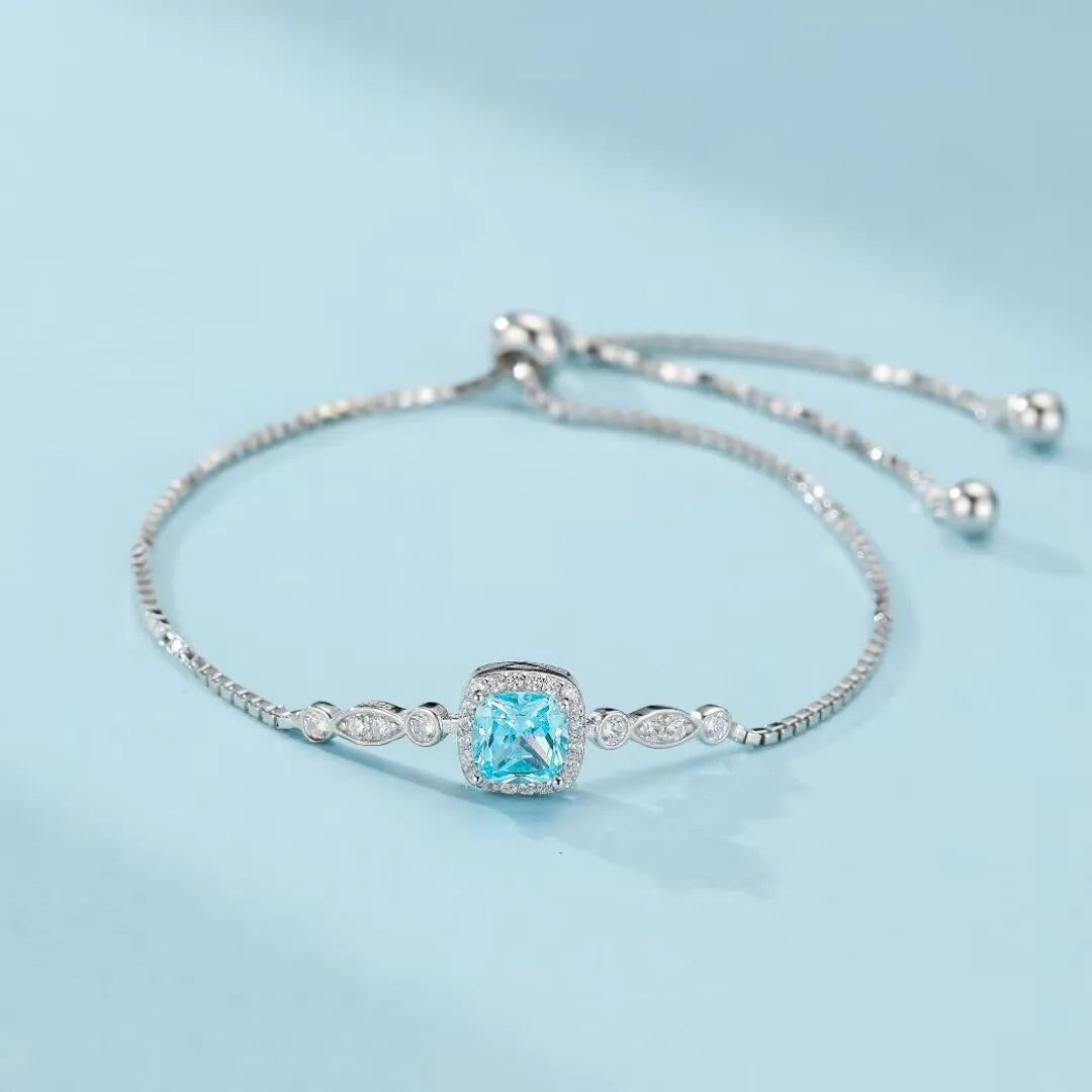 Bracelet "Magie Océanique" en argent 925 orné d'une topaze bleue carrée entourée de petits cristaux brillants.