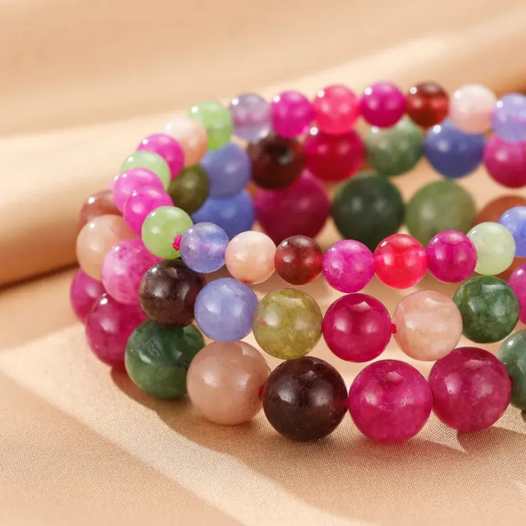 Bracelet "Équilibre Coloré" en tourmalines multicolores, plusieurs bracelets empilés sur un fond beige.