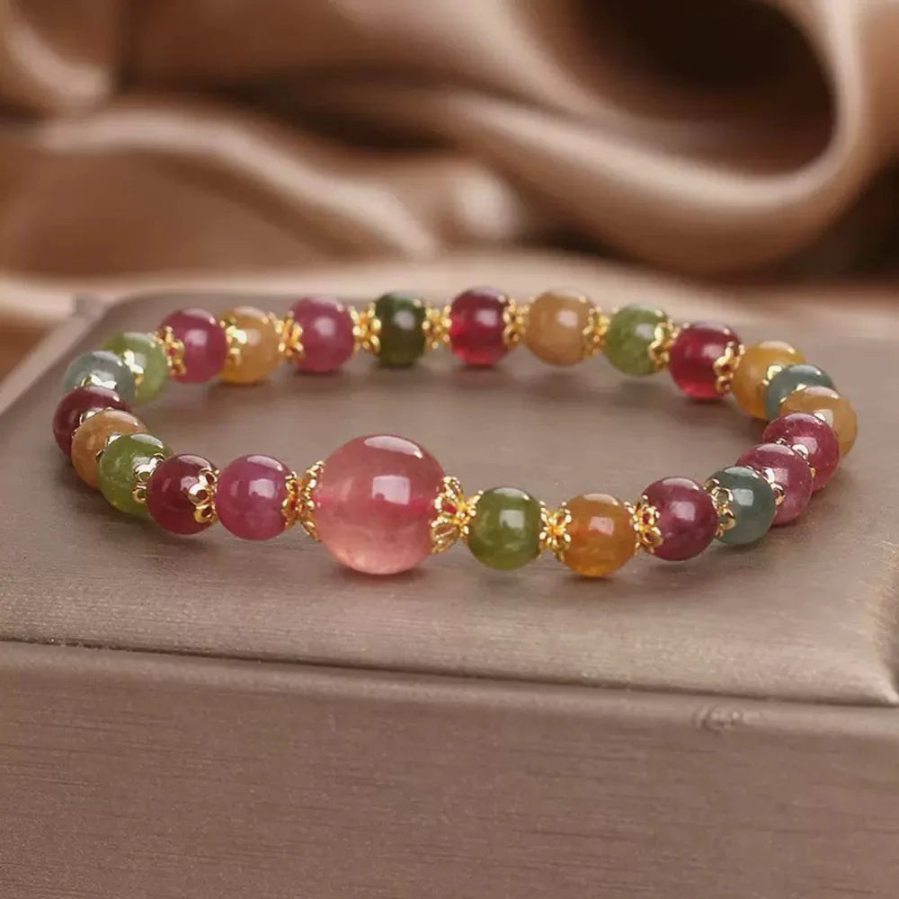 Bracelet "Lumière Colorée" fait de tourmaline et de quartz fraise, avec une perle centrale rose et des perles multicolores serties d'or.