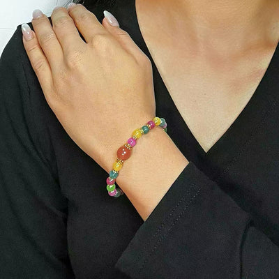 Bracelet coloré "Lumière Colorée" avec des perles rondes de tourmaline et de quartz fraise, porté au poignet d'une femme.