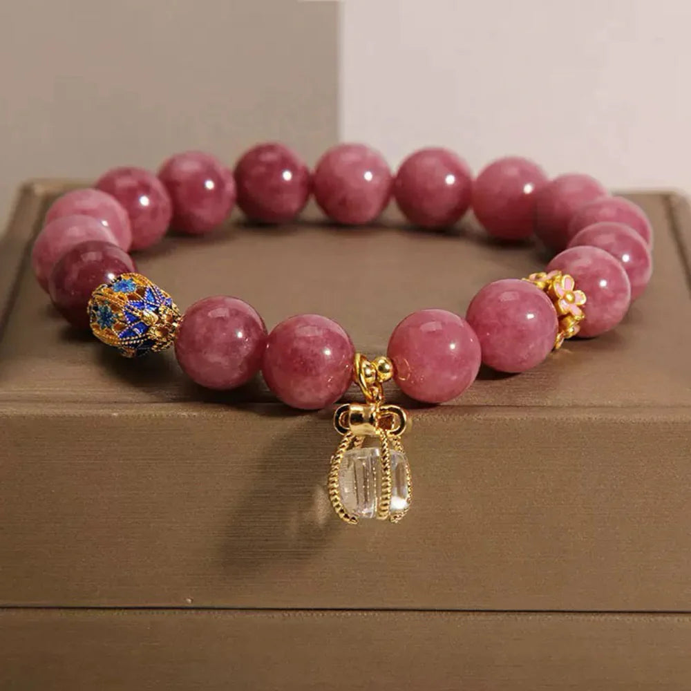 Bracelet élastique "Raffinement Impérial" en tourmaline rose et cristal de roche, orné d'un charmant pendentif en cristal et de détails floraux roses et bleus.