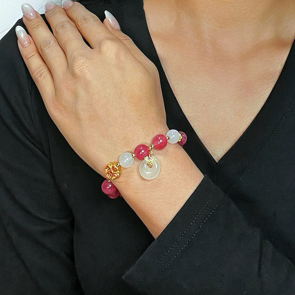 Bracelet "Douceur Éclatante" en tourmaline rose et jade blanc avec un pendentif rond et une perle dorée texturée.