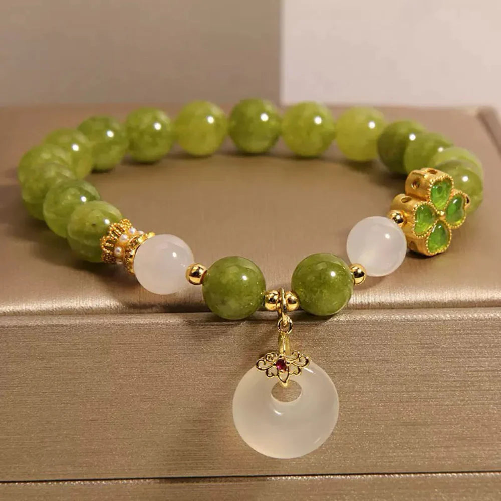 Bracelet Trèfle Tourmaline Verte et Jade "Rayons d'Optimisme" avec breloque ronde en jade blanc et détails dorés.