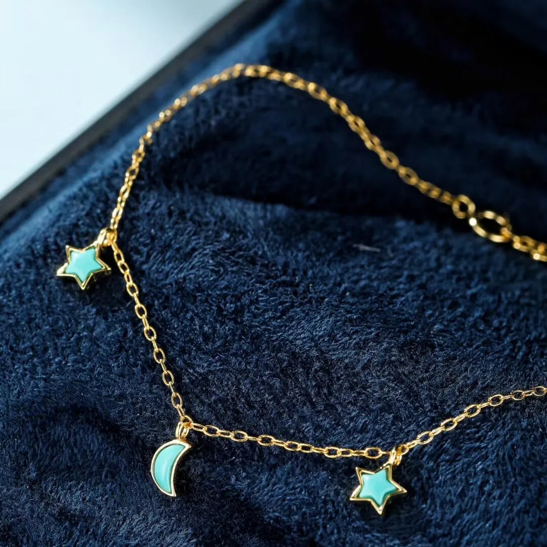 Bracelet fin en argent doré or avec des breloques turquoise en forme d'étoile et de lune, collection "Équilibre Céleste".