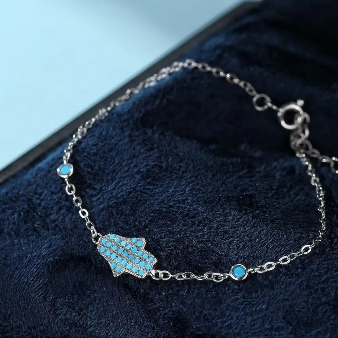 Bracelet en argent 925 avec une main de Fatma ornée de turquoise et de petites perles bleues, fermoir mousqueton.