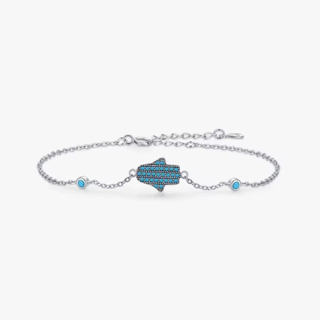Bracelet "Perle Protectrice" en argent 925 avec une main de Fatma ornée de turquoise et deux petites perles bleues de part et d'autre.