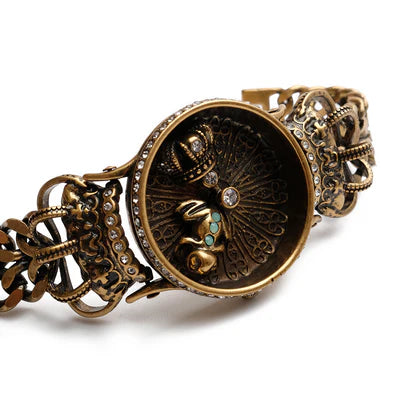 Bracelet vintage en zirconium avec une grenouille royale et une couronne, serti de strass sur un fond blanc.
