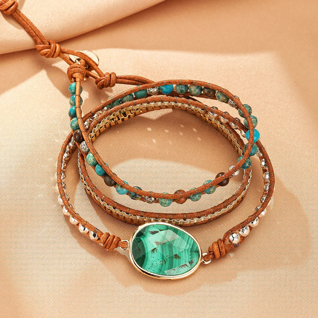 Bracelet jonc enroulé "Profondeur Verte" en malachite avec des perles bleues et argentées sur un cordon en cuir marron.