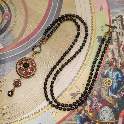Collier Agate "Merveille d'Antan" avec pendentif rond rouge et noir et pierres de gemmes, monté sur une double chaîne de perles noires.