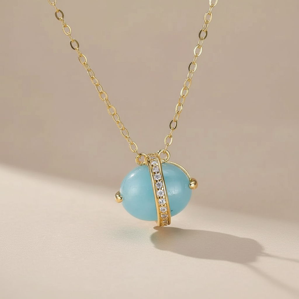 Collier en argent doré à l'or 14K avec une pierre d'aigue-marine bleue ovale et des zircons cubiques incrustés dans une monture argentée.