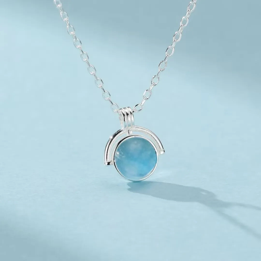 Collier en argent 925 avec un pendentif rond en aigue-marine bleu pâle, monté sur une chaîne fine.