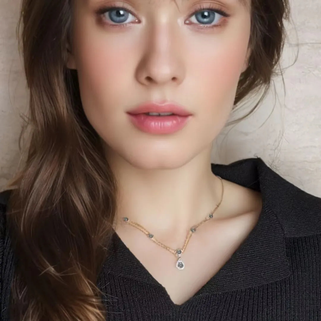 Collier Aigue Marine "Sirène Magique" en Argent avec un pendentif goutte d'eau serti de petites pierres bleues et argentées, porté par un mannequin.