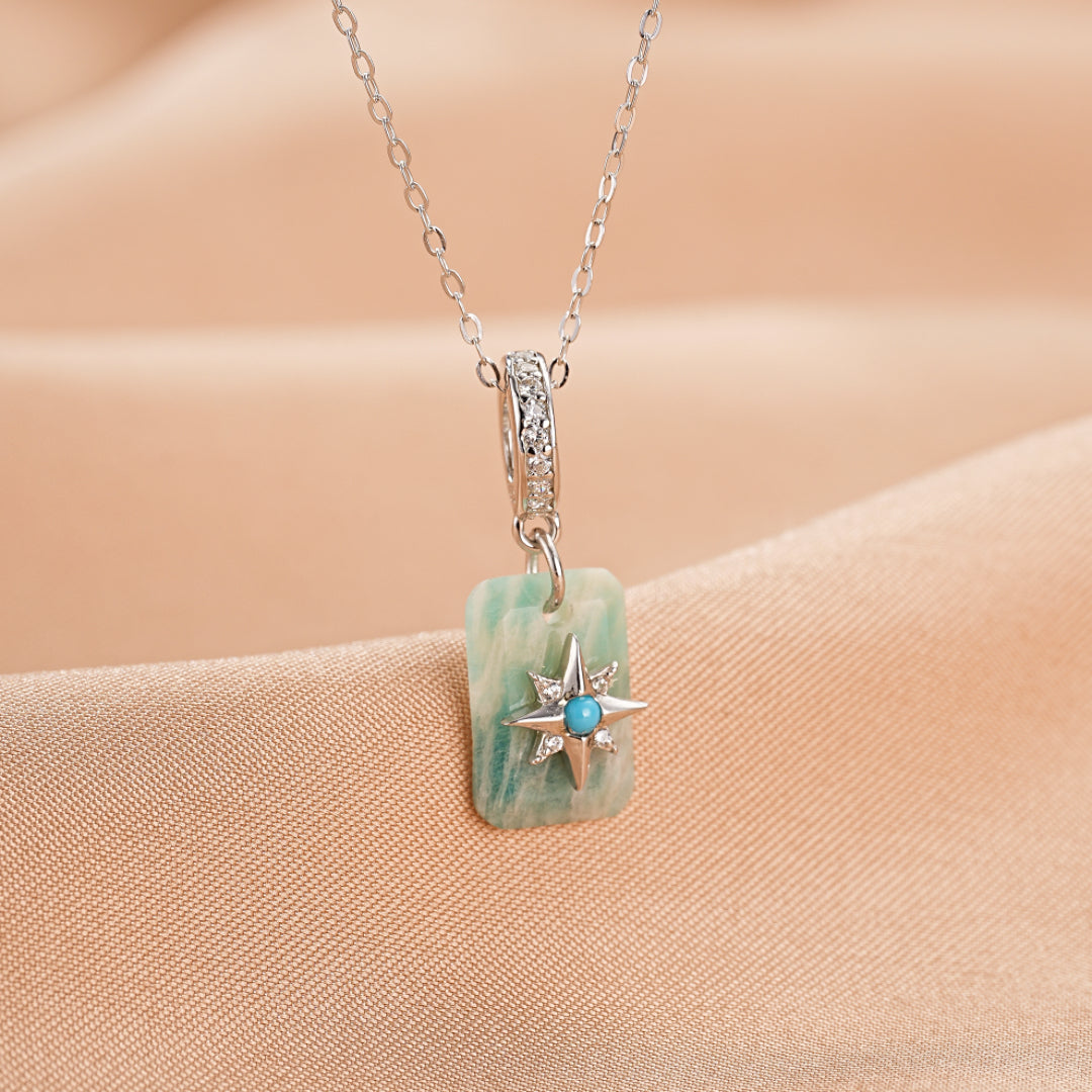 Collier "Éclat Étoilé" en argent plaqué platine avec une amazonite rectangulaire, une étoile à pointes sertie de petites pierres turquoise et de cristaux brillants.
