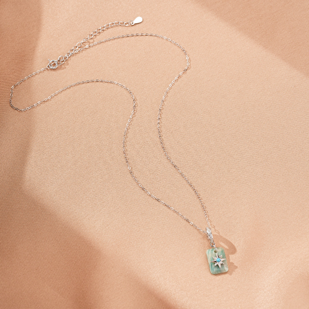 Collier en argent plaqué platine avec un pendentif rectangulaire en amazonite et turquoise orné d'une étoile bleue scintillante.