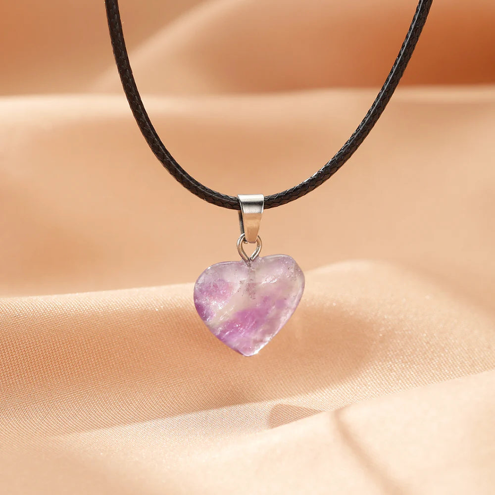 Collier "Cœur Calme" avec pendentif en améthyste naturelle en forme de cœur, monté sur un cordon noir.
