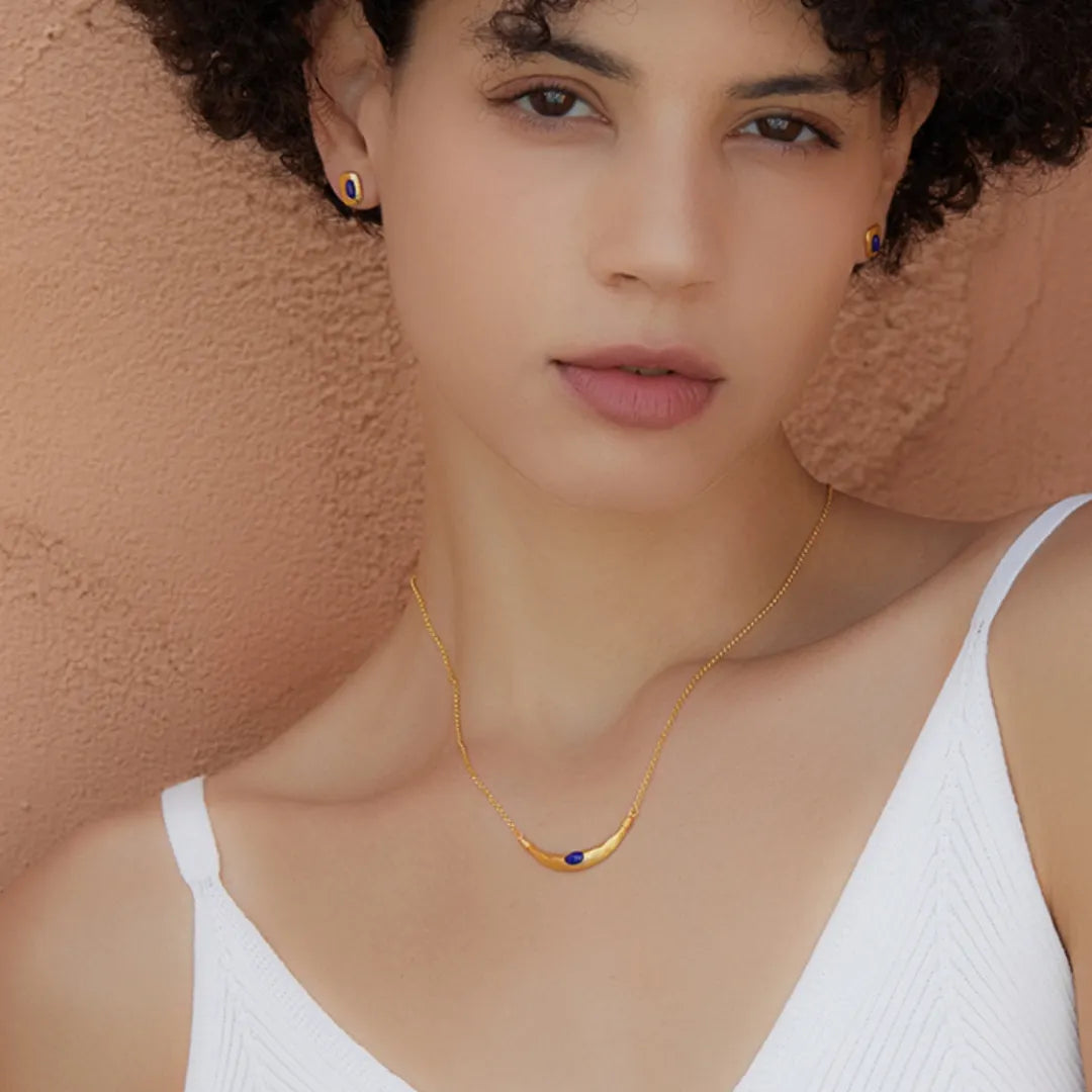 Collier "Allure Mystique" en argent doré à l'or, orné d'un pendentif en forme de croissant de lune serti d'une pierre de lapis-lazuli bleue.