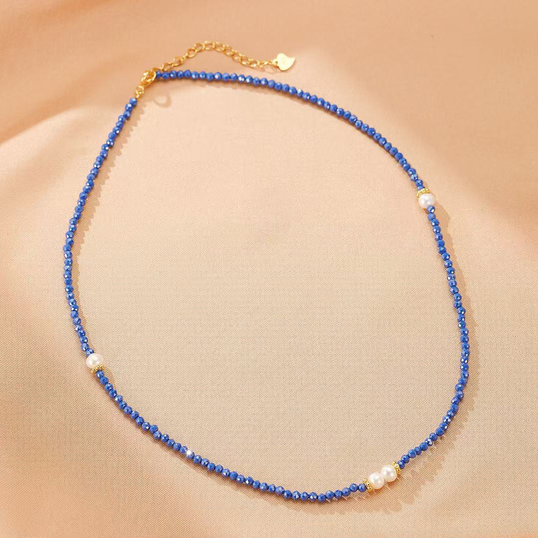 Collier fin "Délicatesse" en lapis lazuli bleu et perles blanches, avec fermoir doré.