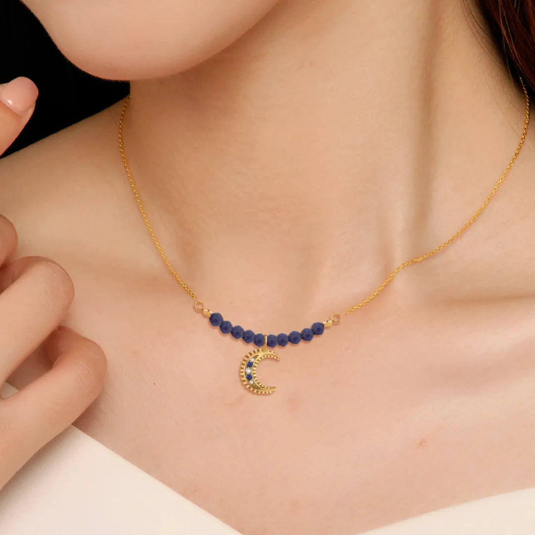 Collier "Nuit Sage" en argent doré à l'or 18 carats avec pendentif croissant de lune orné de lapis-lazuli et de petites perles bleues.