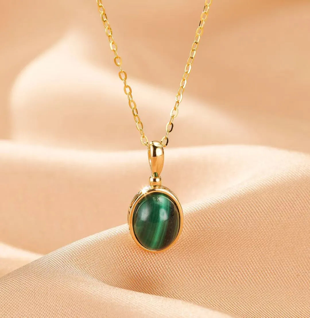 Collier "Aura Antique" en argent doré avec une pierre de malachite verte ovale et une chaîne délicate.
