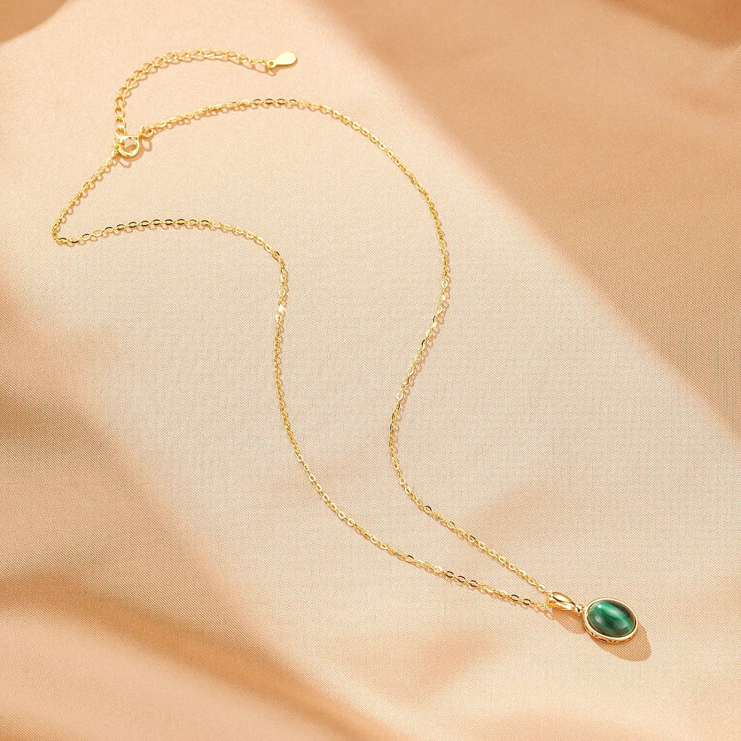 Collier Aura Antique en argent doré avec une pierre de malachite ovale verte.