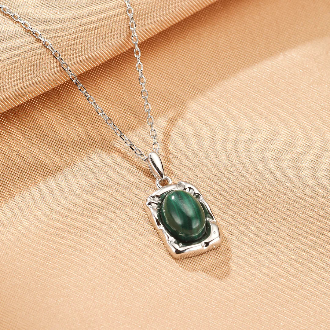 Collier "Élégance Intemporelle" en argent avec une pierre de malachite ovale sertie dans un pendentif rectangulaire texturé.