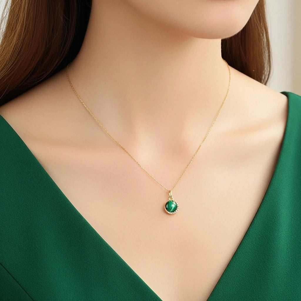 Collier "Halo Éclatant" en argent doré or avec une pierre de malachite centrale entourée de petites pierres scintillantes, porté par une femme.