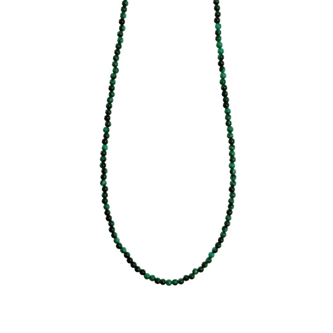Gros plan d'un collier simple en argent 925 avec de petites perles rondes en malachite verte naturelle, disposées sur une chaîne fine.