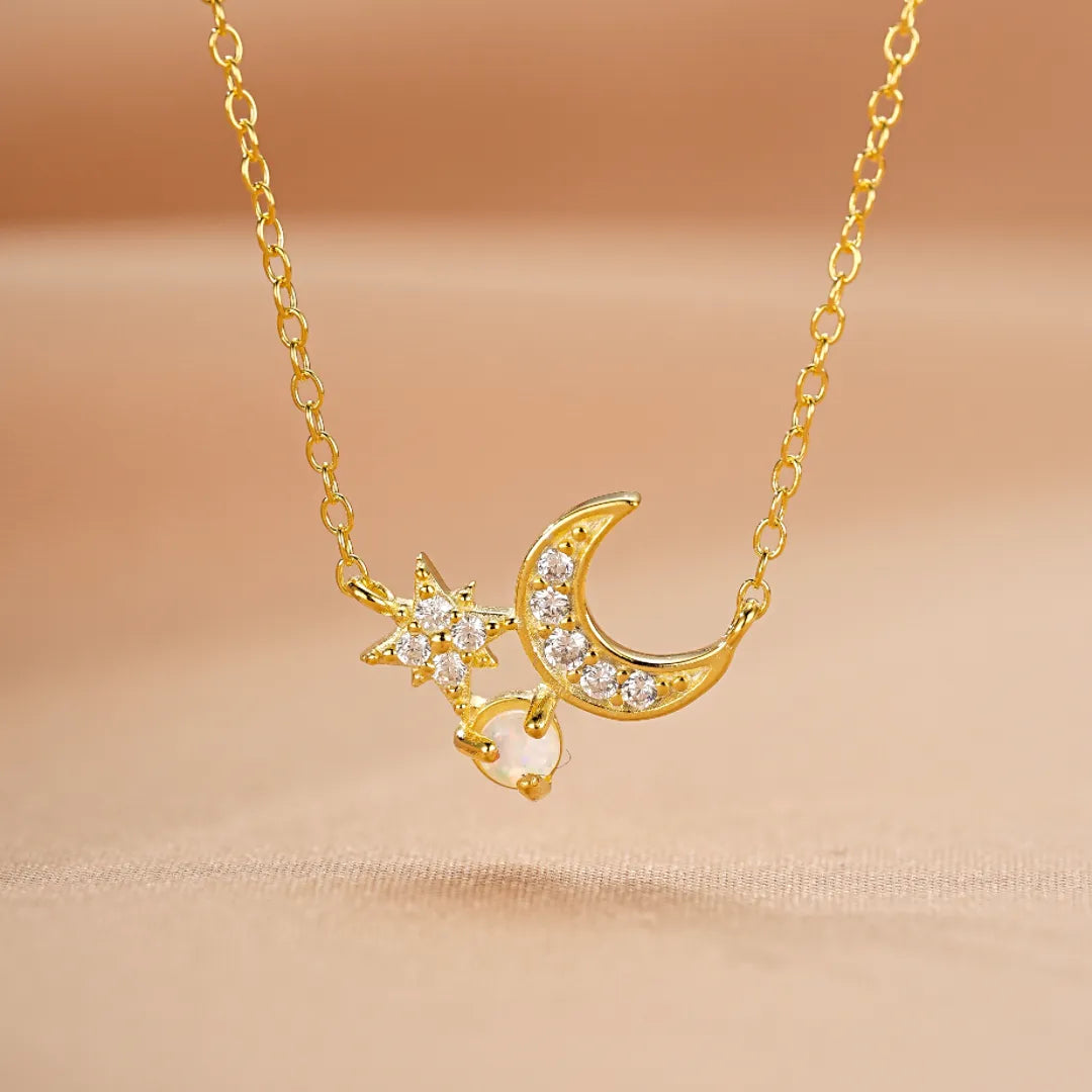 Collier délicat en argent doré or 18 carats avec un pendentif en forme de croissant de lune et d'étoile ornés de zirconiums blancs, et une petite opale nacrée.