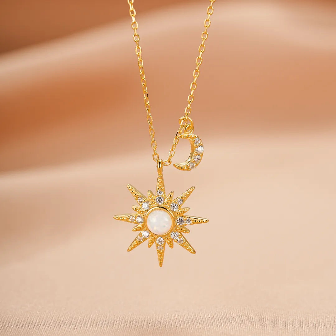 Collier "Énergie Céleste" en argent avec un pendentif soleil en opale blanche entouré de zircons et un petit croissant de lune serti de zircons.
