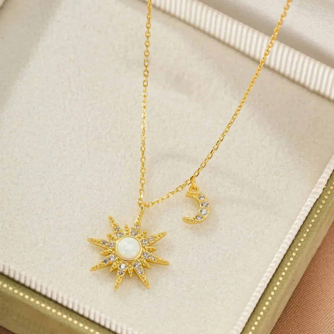 Collier en argent avec pendentif soleil en opale blanche entouré de zircons et un pendentif lune serti de zircons.