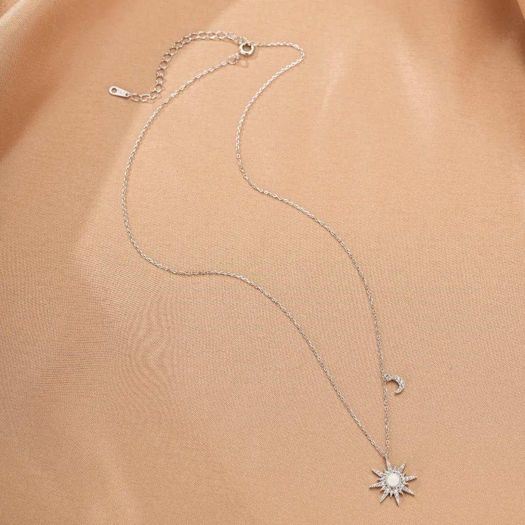 Collier en argent "Énergie Céleste" avec un pendentif soleil et lune orné d'opale et de cristaux.