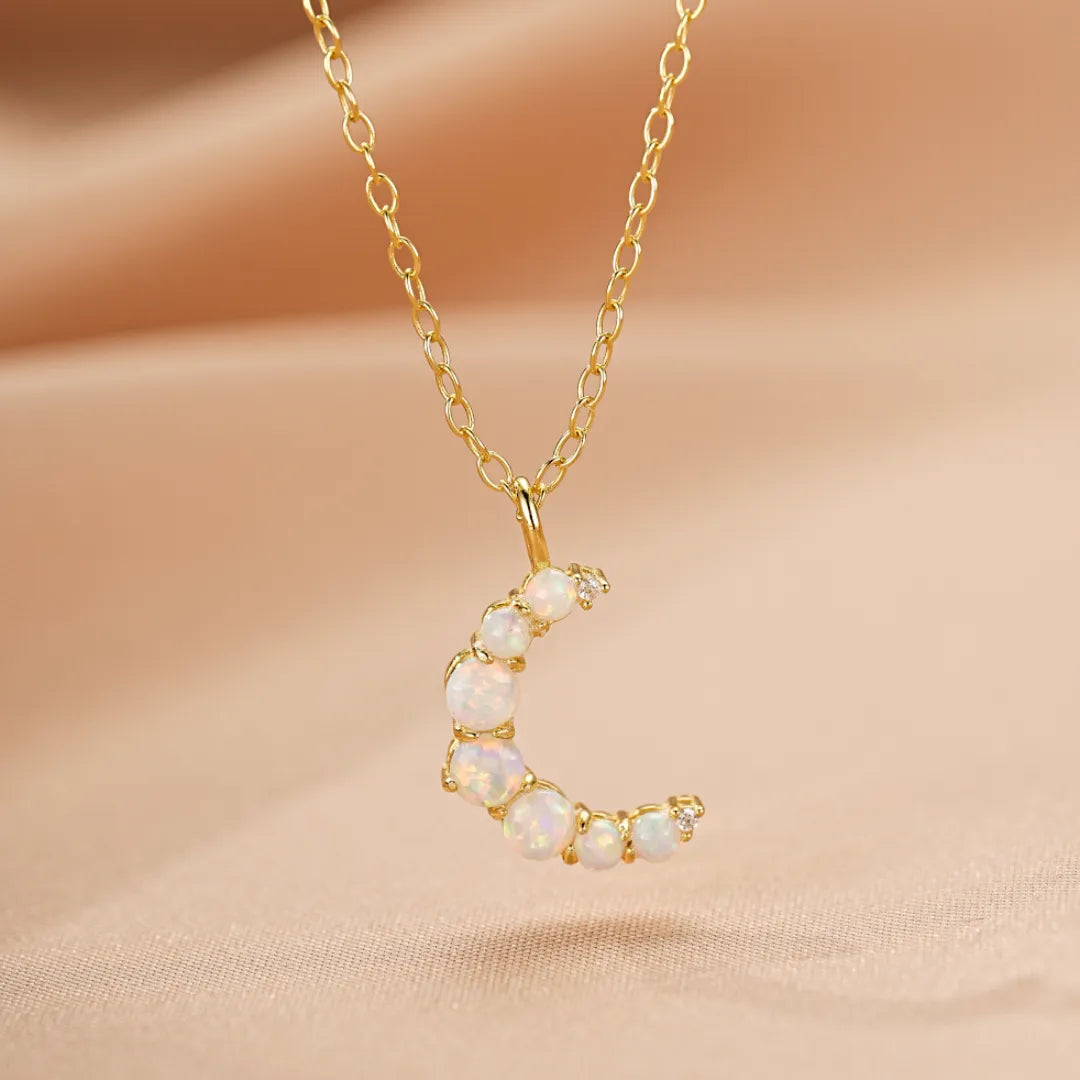 Collier en argent doré or 18K avec pendentif lune serti d'opales et de petites pierres scintillantes, monté sur une chaîne fine.