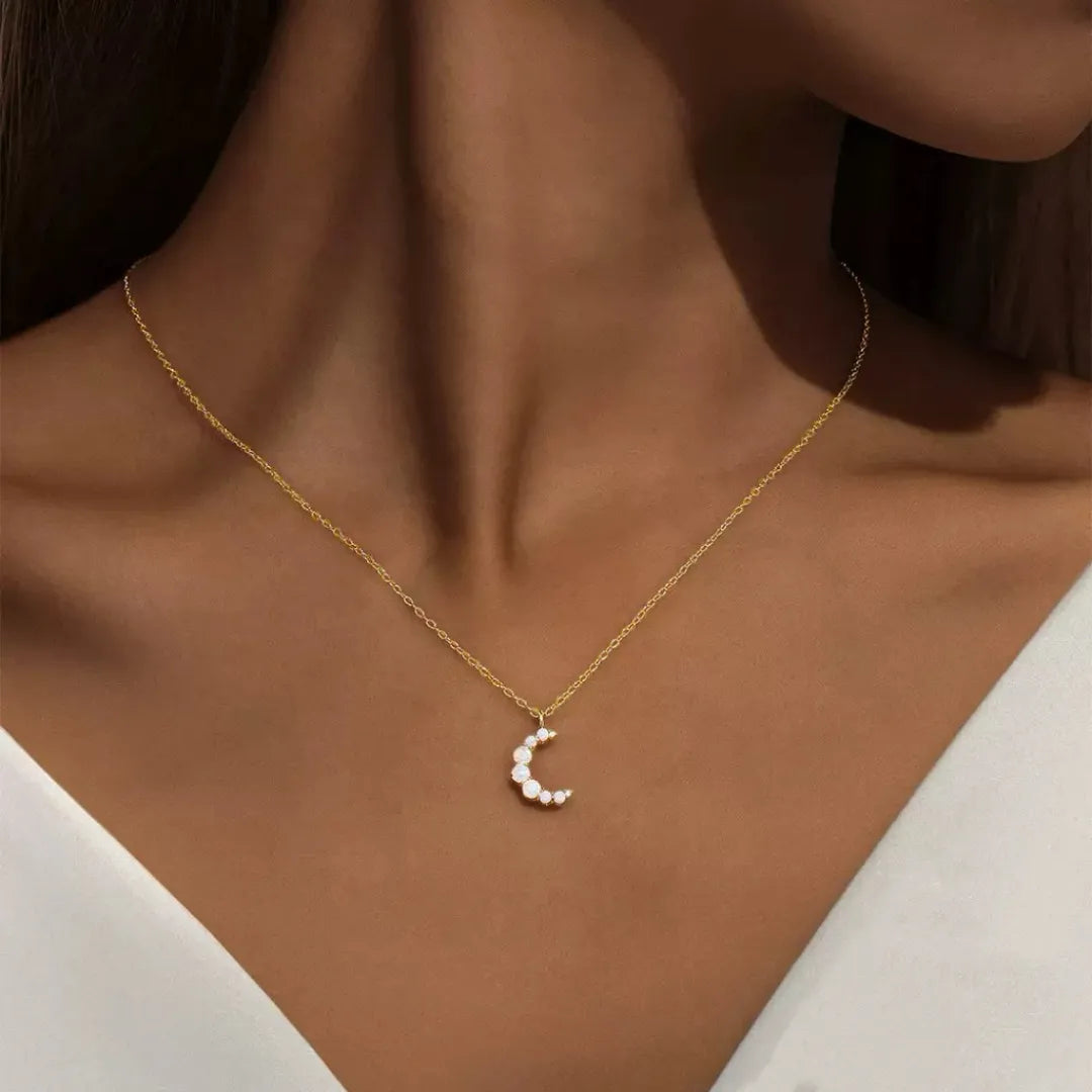 Collier en argent doré or 18K avec pendentif en forme de croissant de lune serti d'opales blanches.