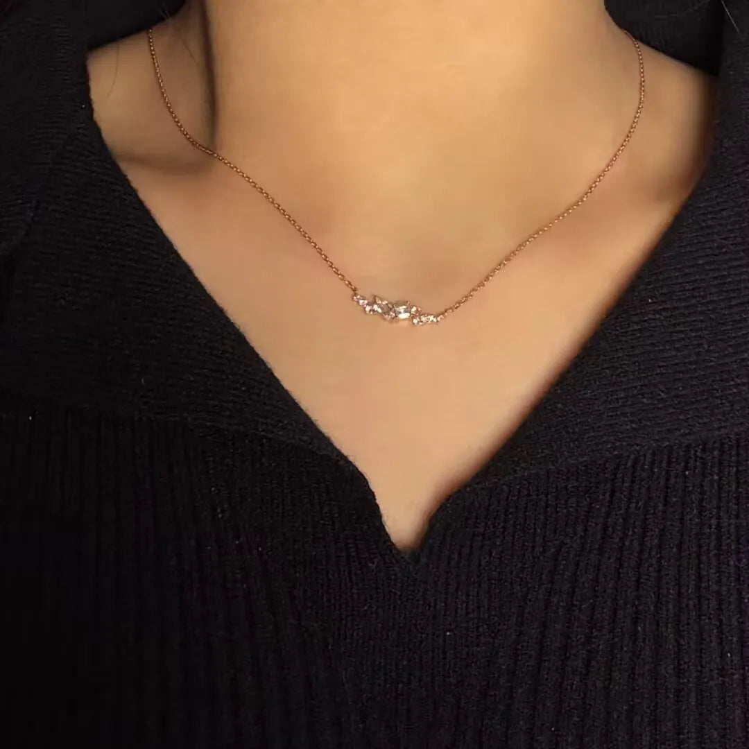 Collier avec pendentif en argent 925 doré à l'or 14K, orné de plusieurs petites pierres scintillantes, porté par une femme.