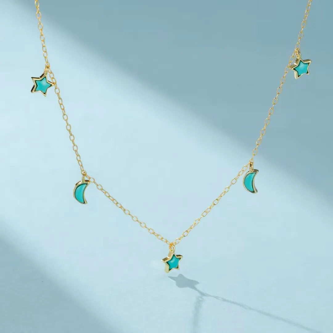 Collier en argent doré or avec pendentifs en forme d'étoiles et de lunes ornés de turquoise, le collier Équilibre Céleste.
