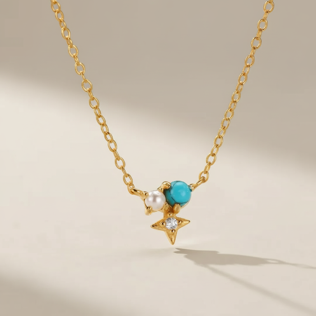 Collier "Sagesse Stellaire" en argent doré or, orné d'une perle blanche, d'une turquoise bleue et d'une étoile sertie d'un petit diamant.