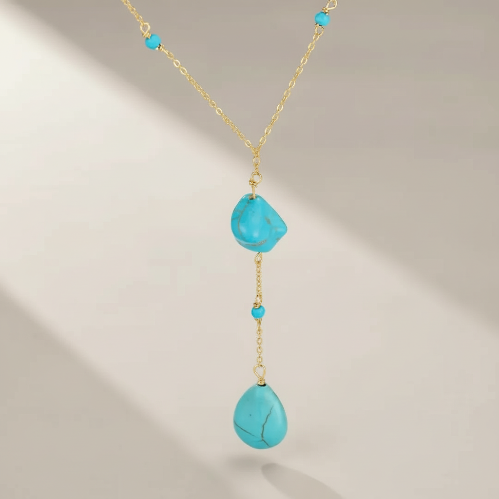 Collier en argent plaqué or avec deux pierres turquoise naturelles en forme de goutte et plusieurs petites perles turquoise montées sur une chaîne délicate.