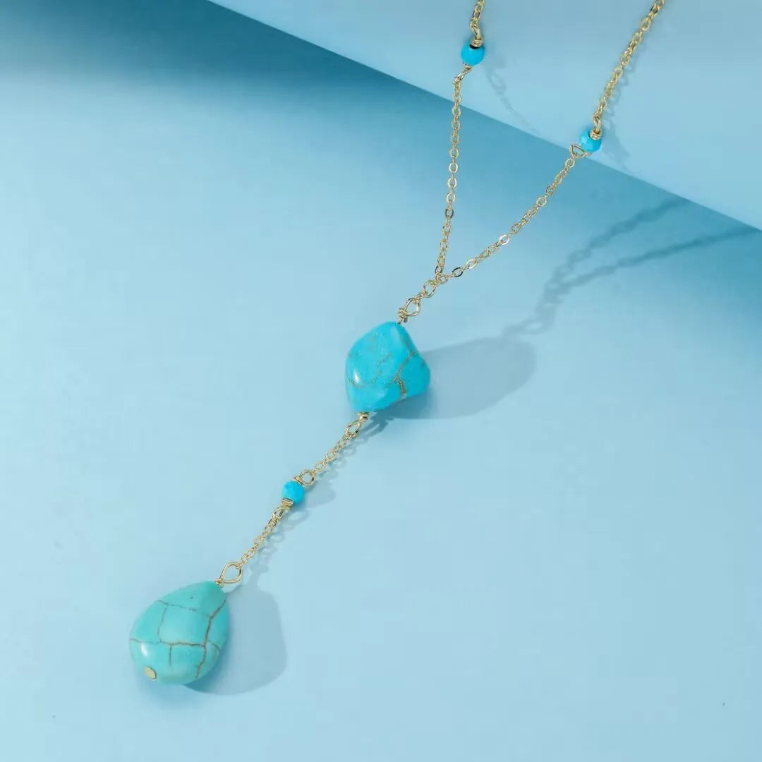 Collier en argent avec pendentif en turquoise naturelle brute et petites perles rondes bleues, style bohème chic.