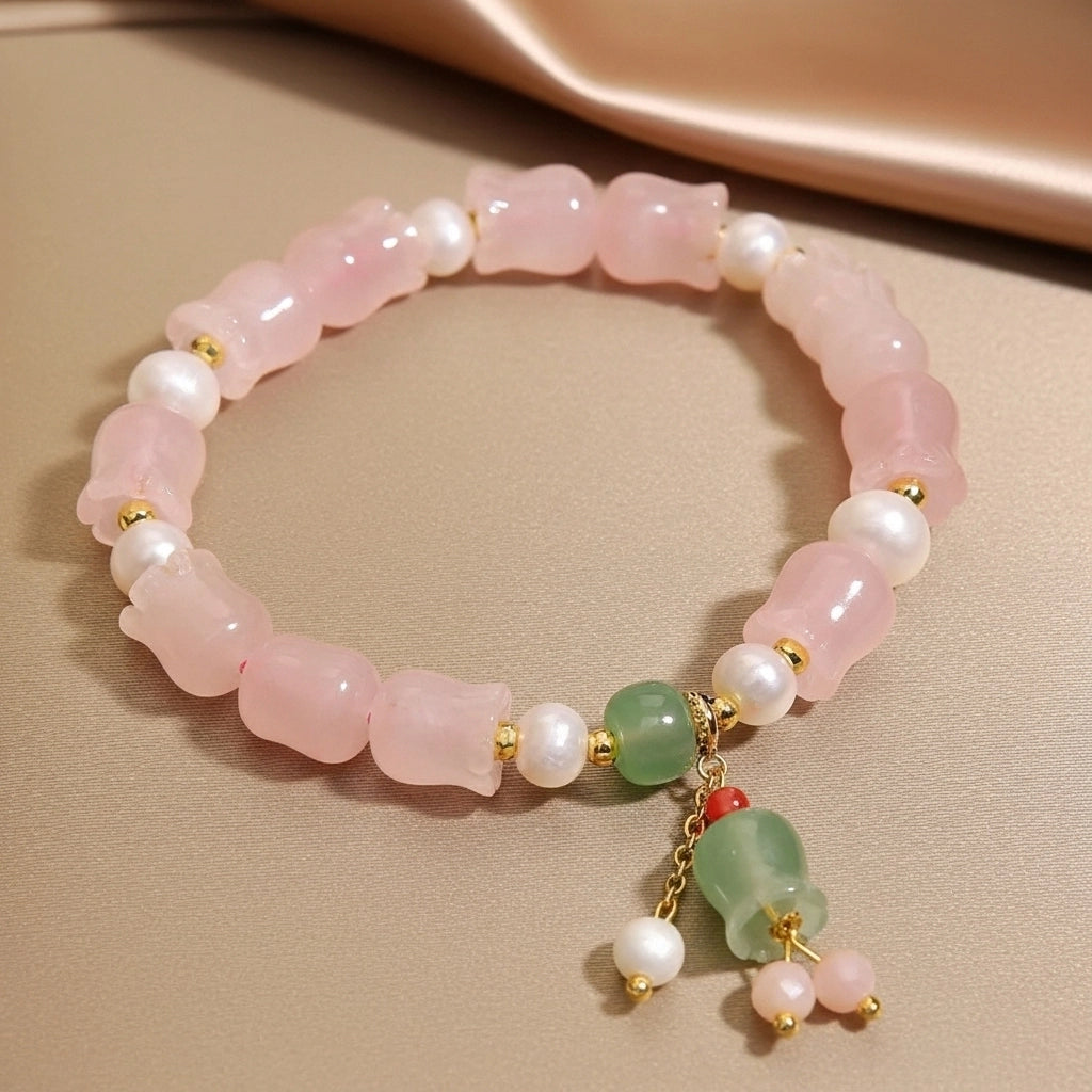Bracelet en quartz rose et perles blanches avec breloques en jade vert et quartz rose.