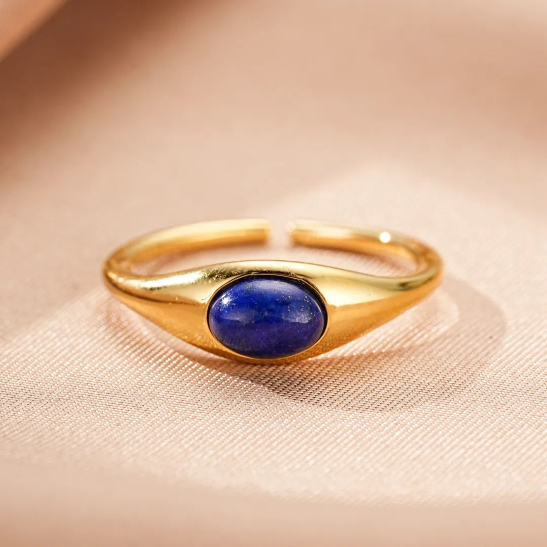 Bague ajustable en argent doré avec une pierre centrale ovale bleu profond en Lapis Lazuli, style minimaliste et élégant.