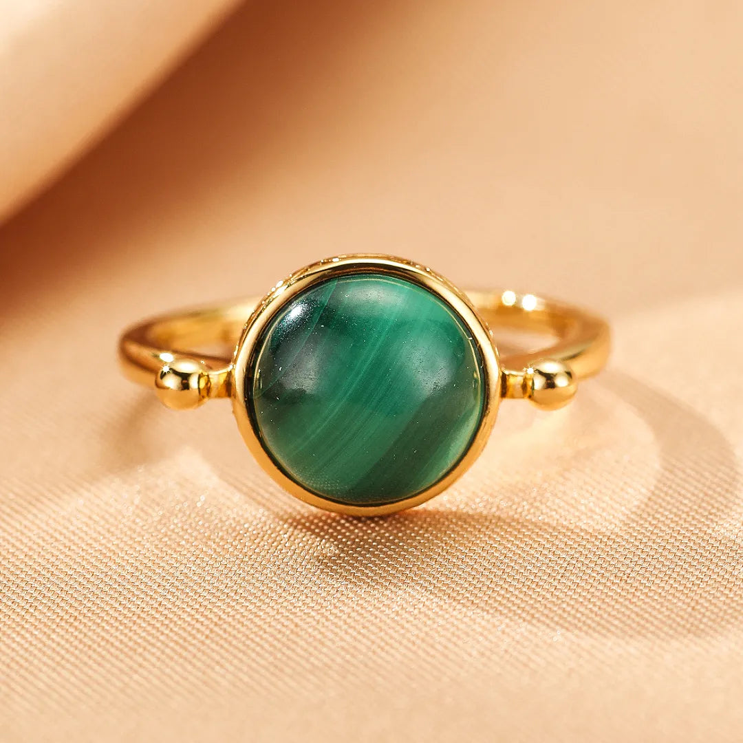 Bague en argent doré sertie d'une pierre de malachite ronde aux motifs concentriques verts, style antique.