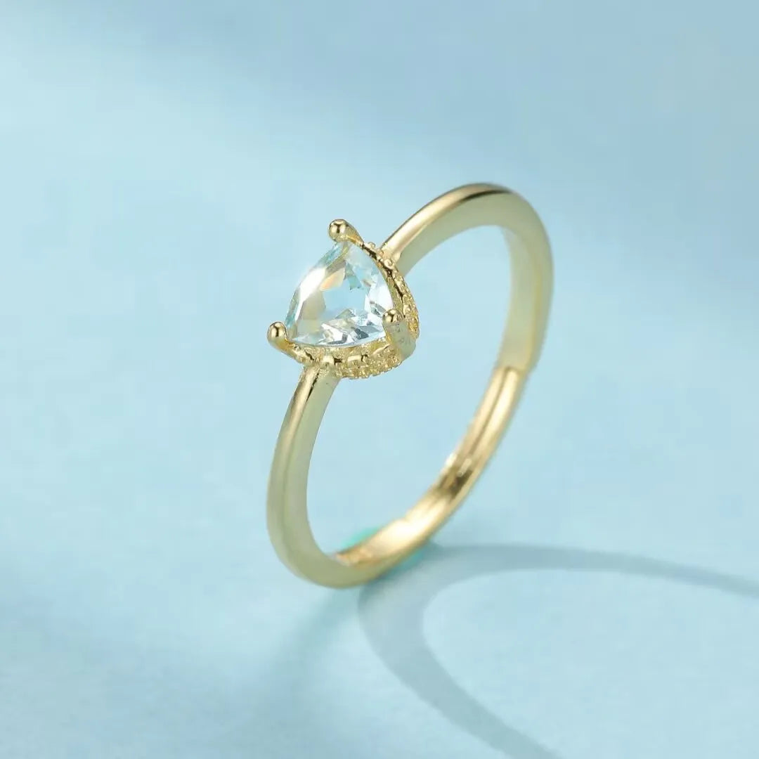 Bague fine en argent doré à l'or 18 carats avec une topaze bleue en forme de goutte, le nom "Clarté Céleste" suggère son éclat.
