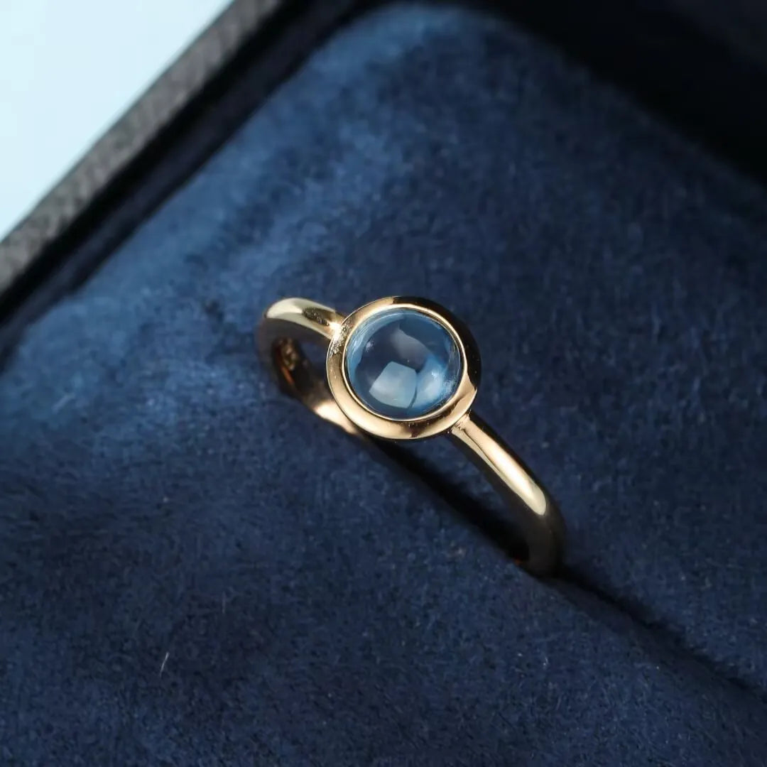 Bague en argent doré sertie d'une topaze bleue ronde, collection "Éclat de l'Aube".