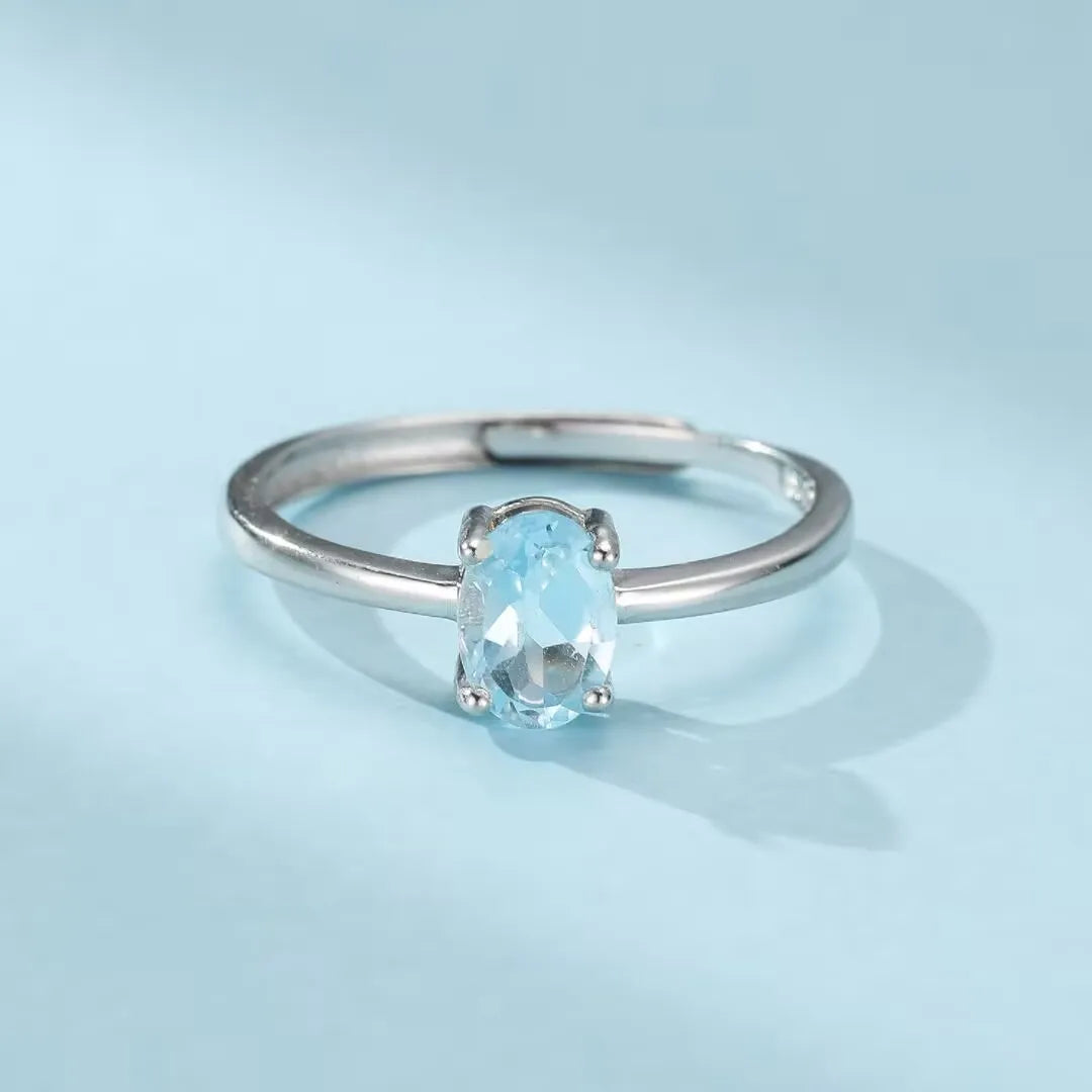 Bague en argent 925 avec une topaze ovale bleu clair, ajustable, nommée Élégance Pure.