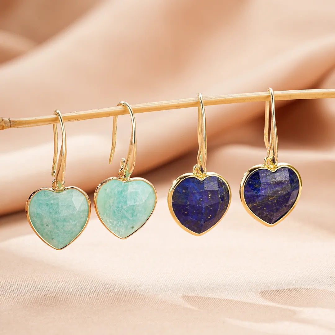 Boucles d'oreilles en forme de cœur en amazonite verte et lapis-lazuli bleu, suspendues à une branche dorée.