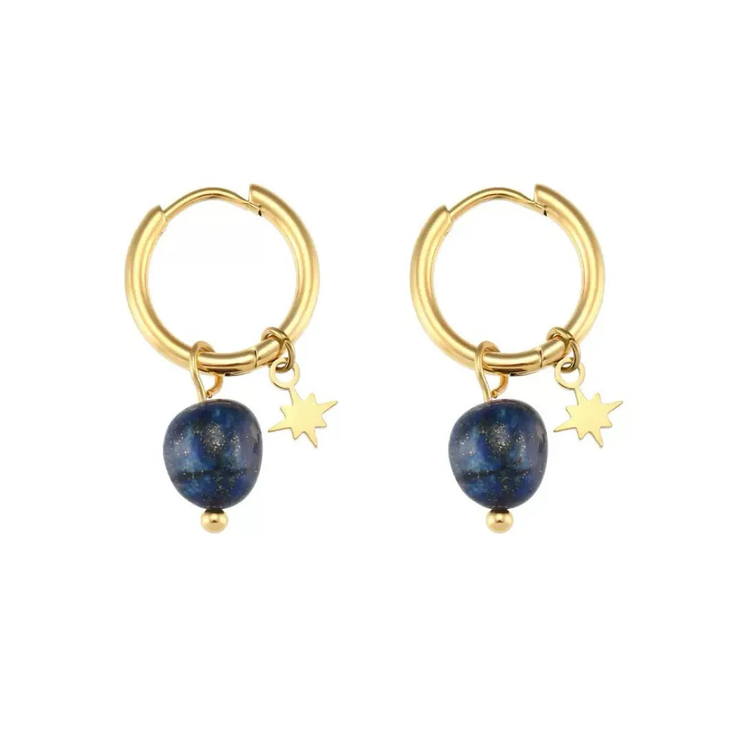 Boucles d'oreilles créoles dorées avec une pierre bleue de lapis-lazuli et une petite étoile dorée suspendues.