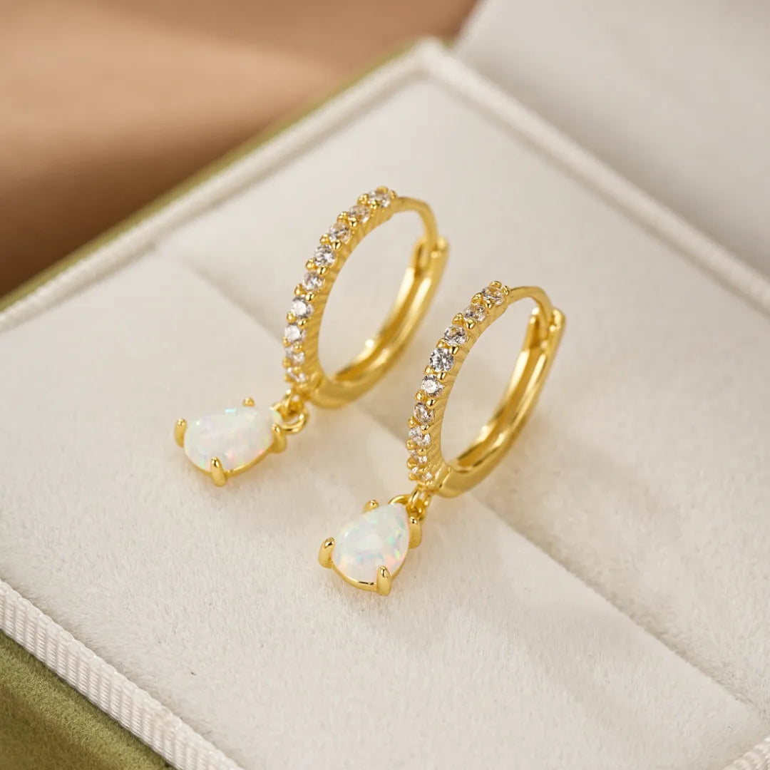 Boucles d'oreilles créoles plaqué or ornées de zircons et d'une petite opale blanche en forme de goutte.