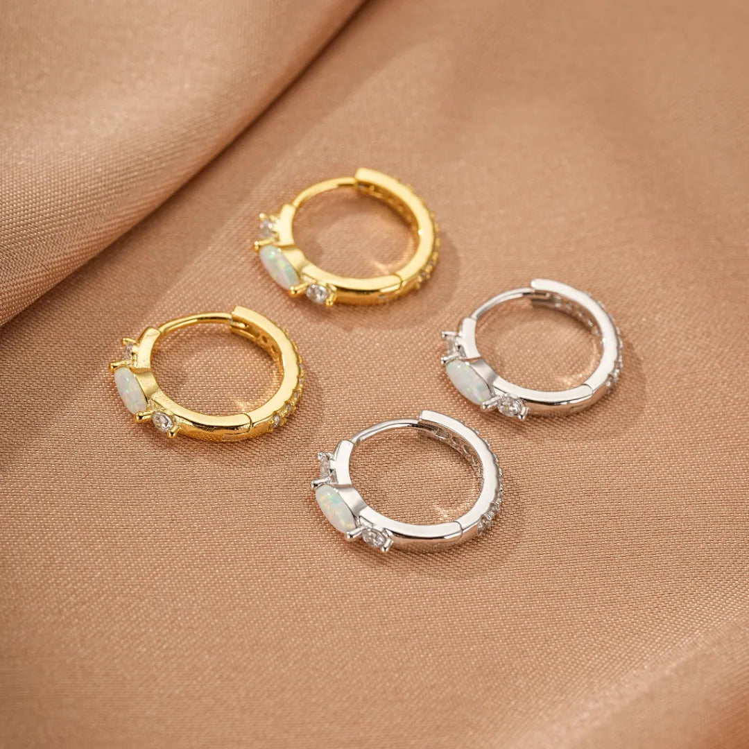 Boucles d'oreilles créoles plaquées or et argent serties d'opales ovales et de petits zircons cubiques scintillants.